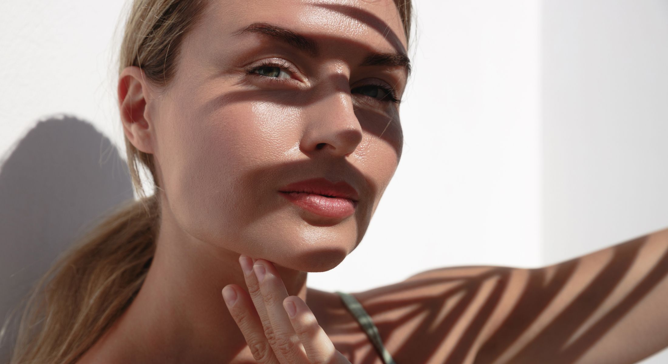 Woman's face illuminated by patterned shadows.