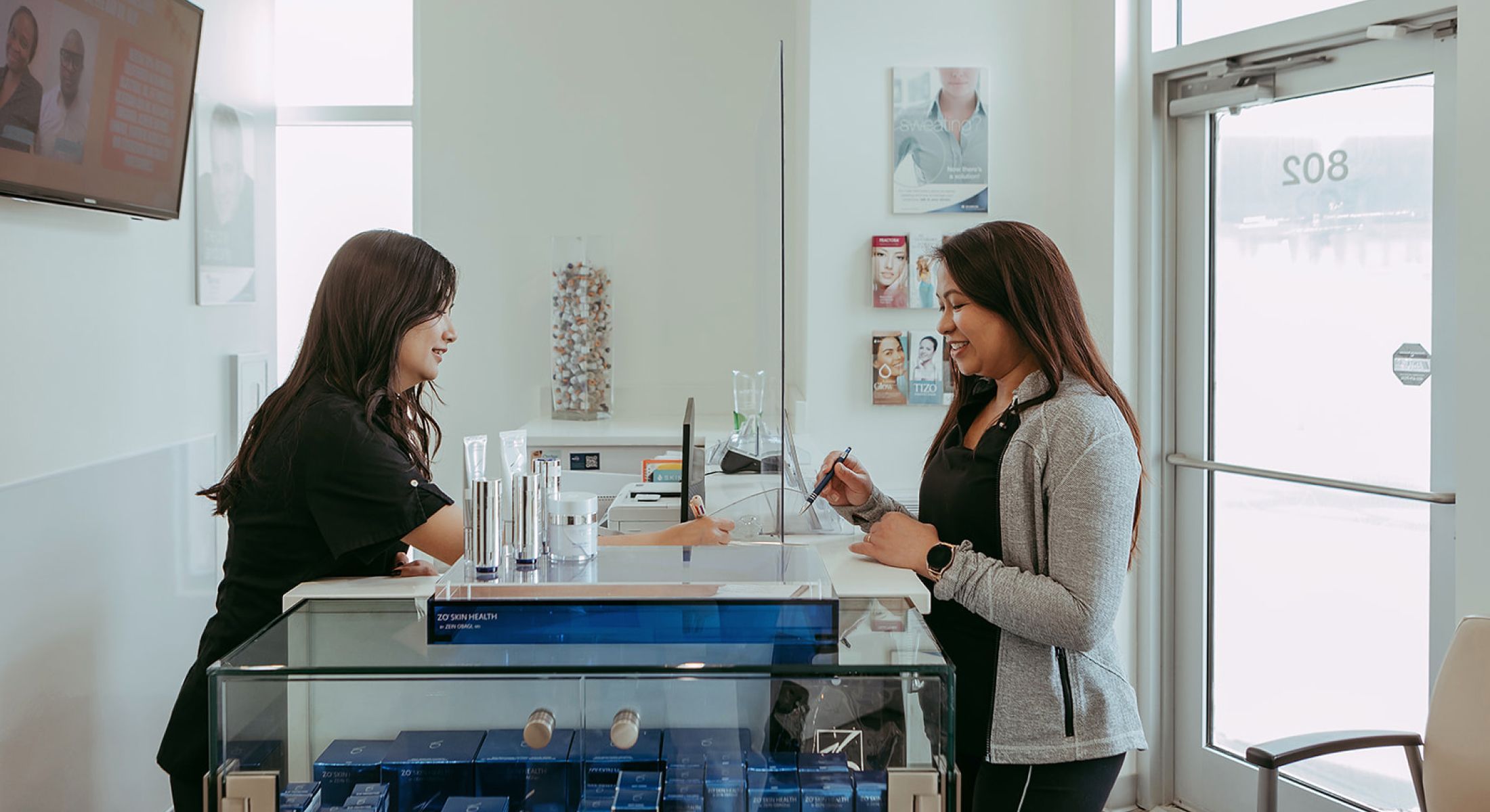 Two women interacting at a retail counter.